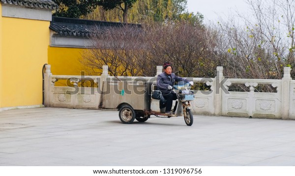 SUZHOU, CHINA, DECEMBER 30, 2018: the man with\
mini motor truck at the Chongyuan Temple is a Liang Dynasty\
Buddhist temple located along Yangcheng Lake at Suzhou Industrial\
Park, Suzhou, China.