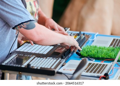 Svetlogorsk, Russia - 08.14.2021 - Disc jockeys playing music, remixing on drum machine midi controller. DJs playing beat sampler with drum pads and samples. Deejays make beats at party, close up