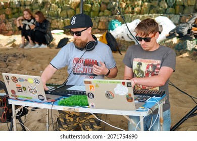 Svetlogorsk, Russia - 08.14.2021 - Disc jockeys playing music, remixing on drum machine midi controller. DJs playing beat sampler with drum pads and samples. Deejays make beats at beach party outside