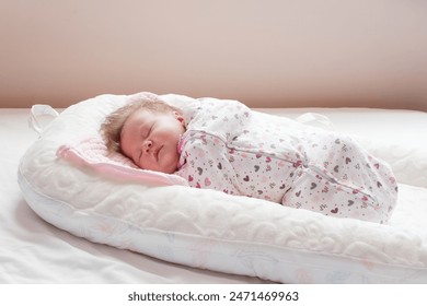 Swaddled Caucasian Newborn baby sleeping in a baby lounger. Baby nest.	 - Powered by Shutterstock