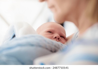 Swaddling newborn child. Baby in swaddle blanket. Tired crying baby wrapped for sleep. Hungry infant in bed. - Powered by Shutterstock