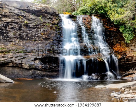 Swallow Falls State Park in the fall in the mountains of Maryland with the creek and waterfalls flowing, cascading in nature, fall foliage and trees to create the perfect fall water landscapes.
