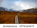 Swampy parts of Kungsleden trail with a wooden path, hiking in September, Lapland, Sweden
