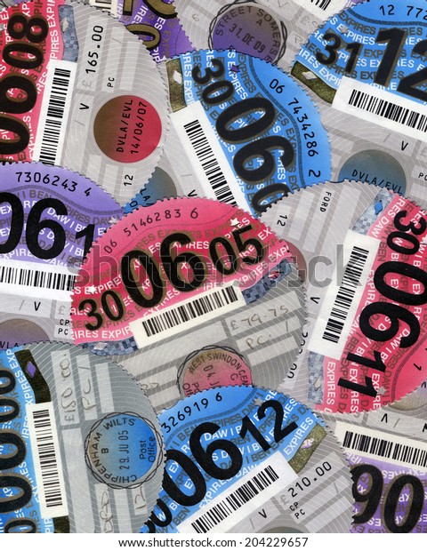 SWANSEA, UK - JULY 11, 2014:\
Photo of a collection of UK car tax discs showing different\
years.