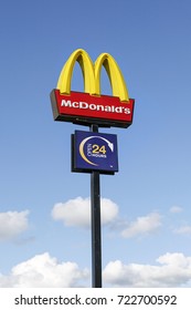 Swansea, UK: September 21, 2017: McDonald's logo on a pole against a blue sky. McDonald's is the world's largest chain of hamburger fast food restaurants and this one is open 24-7