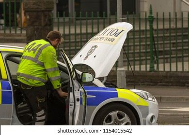 SWANSEA, WALES - JULY 2018: Mechanic From The AA Attending A Broken Down RAF Police Patrol Car In Swansea, Wales.