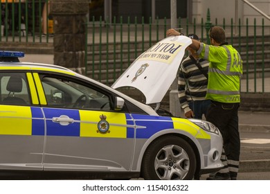 SWANSEA, WALES - JULY 2018: Mechanic From The AA Attending A Broken Down RAF Police Patrol Car In Swansea, Wales.