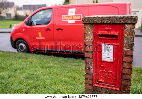 SWANSEA, WALES, UK - DECEMBER 12, 2020: Red\
vintage mailbox for letters and Royal Mail van, British postal\
service and courier\
company