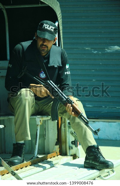 Swat, Khyber Pakhtunkhwa / Pakistan - April 12 2016\
- Policeman is on duty of for tourist protection and sitting in\
police car with rifle