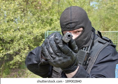 Swat Police Officer Pointing A Gun At The Camera, Close-up