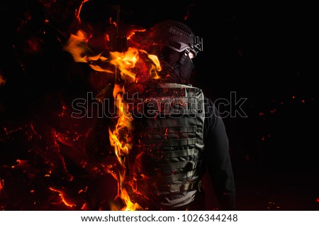 Swat soldier with fire effects. Photo of a swat soldier`s back with flame effect on black background.