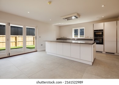 Swavesey, Cambridgeshire, England - May 21 2019: Modern Kitchen In Recently Completed Vacant New Home With Peninsular Island And Bifold Patio Doors