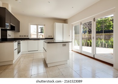 Swavesey, Cambridgeshire, England - May 21 2019: Modern Kitchen In Recently Completed Vacant New Home With Peninsular Island And Bifold Patio Doors