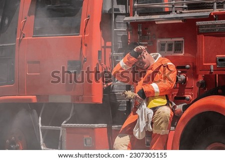 Sweat dripped from the firefighter's forehead as he sit leaned against the firetruck their exhausted body seeking support after the grueling task of rescuing the victims.
