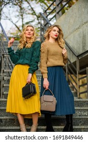 Sweater Skirt Trend. Matching Outfits. Women Sisters Outdoors Stairs Background. Matching Colors. Personal Stylist Service. Completing Each Other. Vogue Concept. Girls Blonde Wear Matching Clothes.