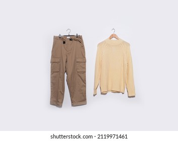 Sweaters With Khaki Pants On Hanger On The Gray Background