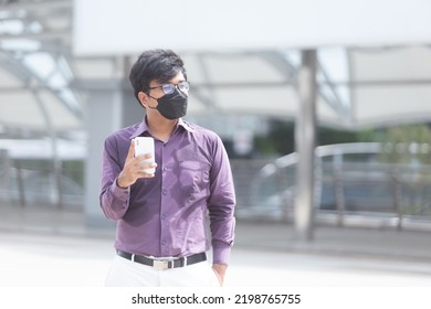 Sweating Asian Business Man Wearing Face Mask Using Mobile Phone During Office Hours As Part Of Business New Normal