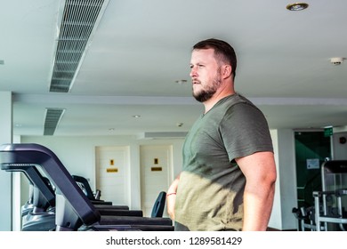 Sweating Chubby Man Walking On Running Track, Warming Up On Gym Treadmill