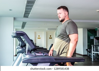 Sweating Chubby Man Walking On Running Track, Warming Up On Gym Treadmill