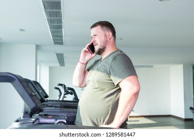 Sweating Chubby Man Walking On Running Track, Warming Up On Gym Treadmill