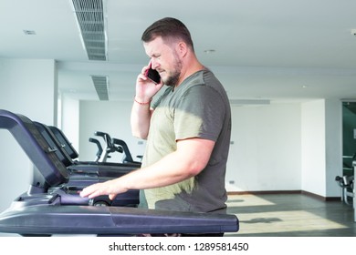 Sweating Chubby Man Walking On Running Track, Warming Up On Gym Treadmill