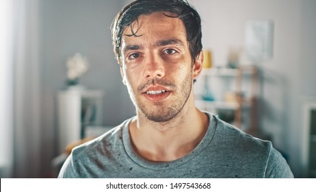 Sweating Muscular Athletic Fit Man In Grey Outfit Is Posing After A Workout At Home In His Spacious And Sunny Living Room With Minimalistic Interior.