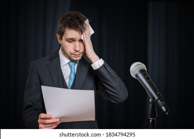 Sweating Nervous Speaker Is Afraid Of Public Speech. Microphone In Front.