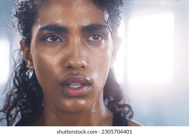 Sweating, woman breathing and face taking a break from fitness, exercise and workout. Gym, Indian female person and tired face of an athlete after sports and wellness club training for health - Powered by Shutterstock