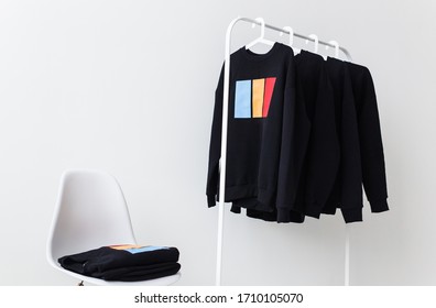 Sweatshirts and hoodies hanging on hangers in the store. Street fashion, unisex and youth wears. - Powered by Shutterstock