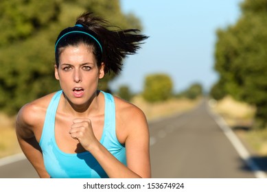 Sweaty Female Athlete Running On Rural Road. Hispanic Woman Training Sprint And Exercising Hard For Intense Marathon.