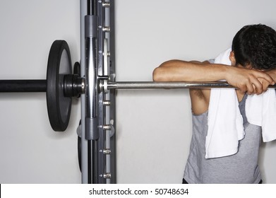 Sweaty Man Resting On Barbell After Workout