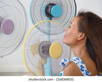 Sweaty Woman's Face With Fans In The Background 