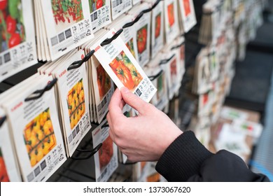 JÖNKÖPING, SWEDEN - APRIL 14, 2019: Hand Picking The Right Plant Seeds In The Store To Plant In The Greenhouse In The Garden At Home.