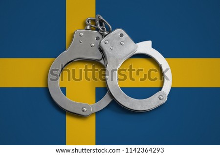 Sweden flag  and police handcuffs. The concept of observance of the law in the country and protection from crime