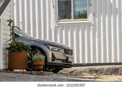 Kungälv, Sweden - July 15 2022: A Polestar 2 Electric Car Looking Out From Behind A White House.