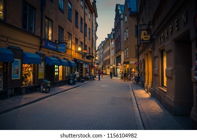 Sweden, Stockholm, May 29, 2018: traditional typical narrow streets with cobblestone, cafes, restaurants, shops, bikes in old historical town quarter Gamla Stan at sunset, dusk, twilight, evening - Shutterstock ID 1156104982