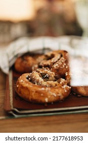 Swedish Cinnamon Buns On A Tray With A Kitchen Towel Covering Some Of Them