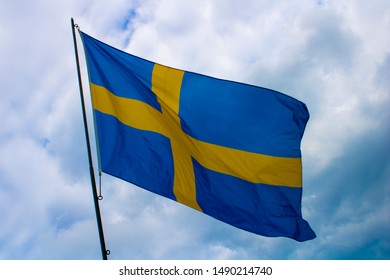 The Swedish flag with clouds in the background.