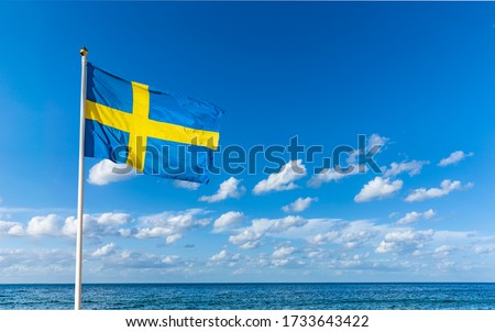 Swedish flag in the wind against a blue sky