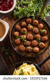 Swedish food Kottbullar meatballs, served in a pan with mashed potatoes, parsley and cranberry sauce.
