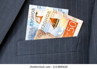 Swedish kronor banknotes sticking out of the businessman suit pocket. Money in the pocket of business suit
