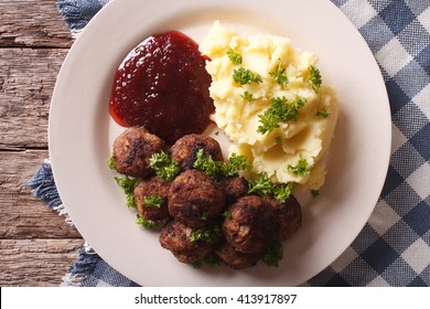 Swedish meatballs kottbullar, lingonberry sauce with a side dish mashed potato on the plate closeup. horizontal view from above

