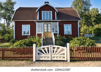 Swedish red and white traditional house in Smalland, White fence green garden blue sky. Childhood memories from the vacations in Sweden. Nature photo from Scandinavian landscape. - Shutterstock ID 2204122387