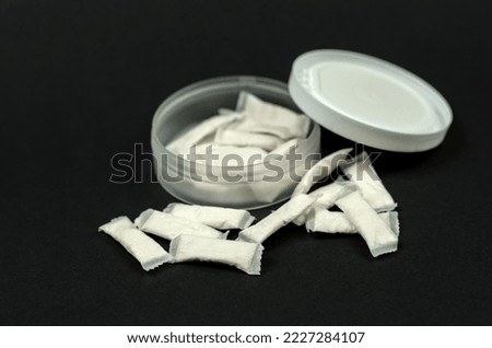 Swedish snus sachets. Open box with snus on a black background.