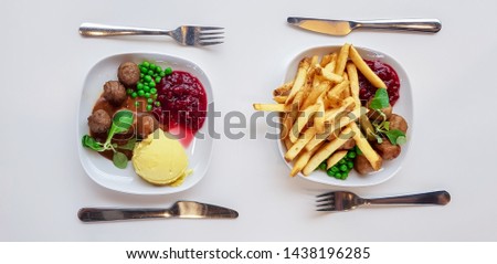 Swedish traditional meatballs with boiled potatoes and sweet potato fries  with cranberry sauce in cafe IKEA. 