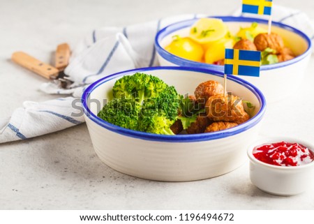Swedish traditional meatballs with broccoli, boiled potatoes and cranberry sauce. Swedish food concept.