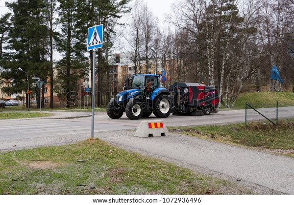 Sweeper cleaning the road in the town of Boras in\
sweden april 2018