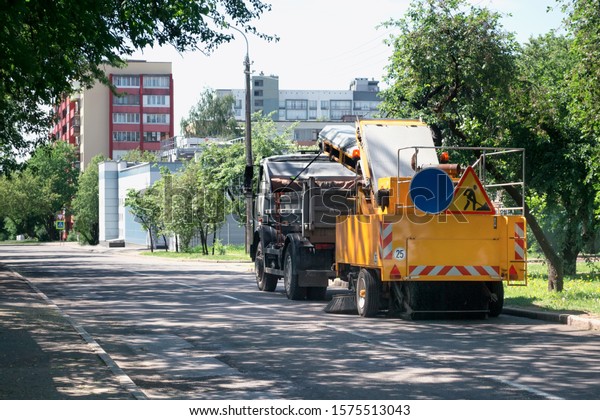 Sweeper\
machine in the process of cleaning the\
street