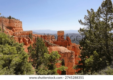 A sweeping landscape of eroding sandstone mountains with evergrren trees at Agua Canyon in Bryce Canyon National Park, Utah, USA