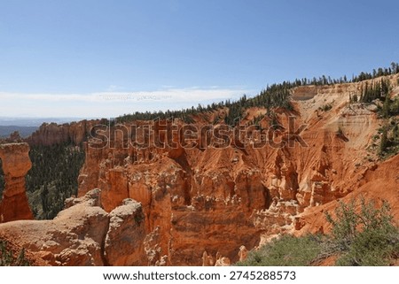 A sweeping landscape of eroding sandstone mountains with evergrren trees at Agua Canyon in Bryce Canyon National Park, Utah, USA